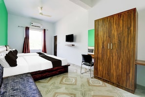 A bedroom with a bed, a desk, a wardrobe, and a television. - Collection Salasar Balaji Formerly (Jaipur)