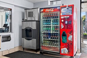 Ein Getränkeautomat mit Coca-Cola-Logo, Wasserspender und Zahlungsterminal.