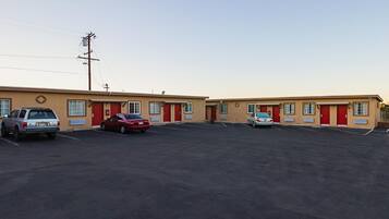 A motel with two-story buildings, a parking lot, and a utility pole.