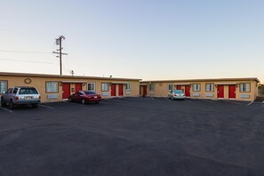A motel with two-story buildings, a parking lot, and a utility pole.