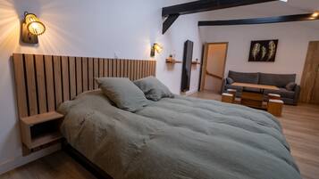 Een moderne slaapkamer met een houten hoofdbord, een groot bed, nachtkastjes en een ingebouwde bank.