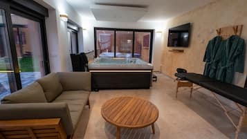 A modern living room with a sofa, a round wooden table, a hot tub, and a bench.
