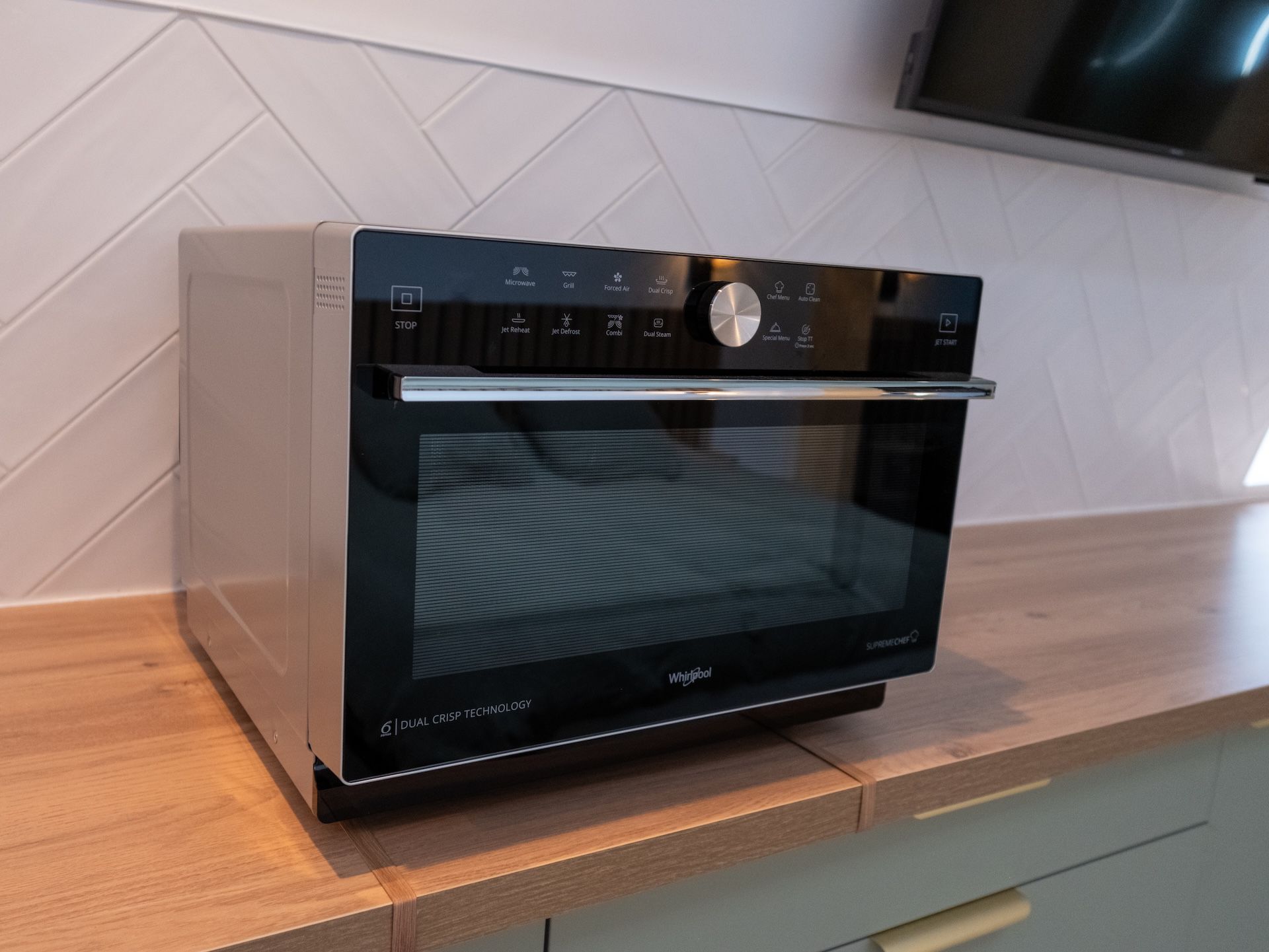 Een moderne keuken met een inbouwoven en magnetron.