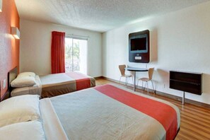 A hotel room with two beds, a TV, a desk with chairs, and a window with curtains. - 2 QUEEN BEDS | MICFRIDGE (SANTA ANA)