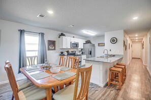 A modern kitchen with white cabinets, a stainless steel refrigerator, and a built-in microwave. - 7 Mi to Beach! Group & Pet-Friendly Palm Coast Gem (Palm Coast)