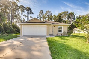 A single-story house with a garage, a front door, and a small porch. - 7 Mi to Beach! Group & Pet-Friendly Palm Coast Gem (Palm Coast)