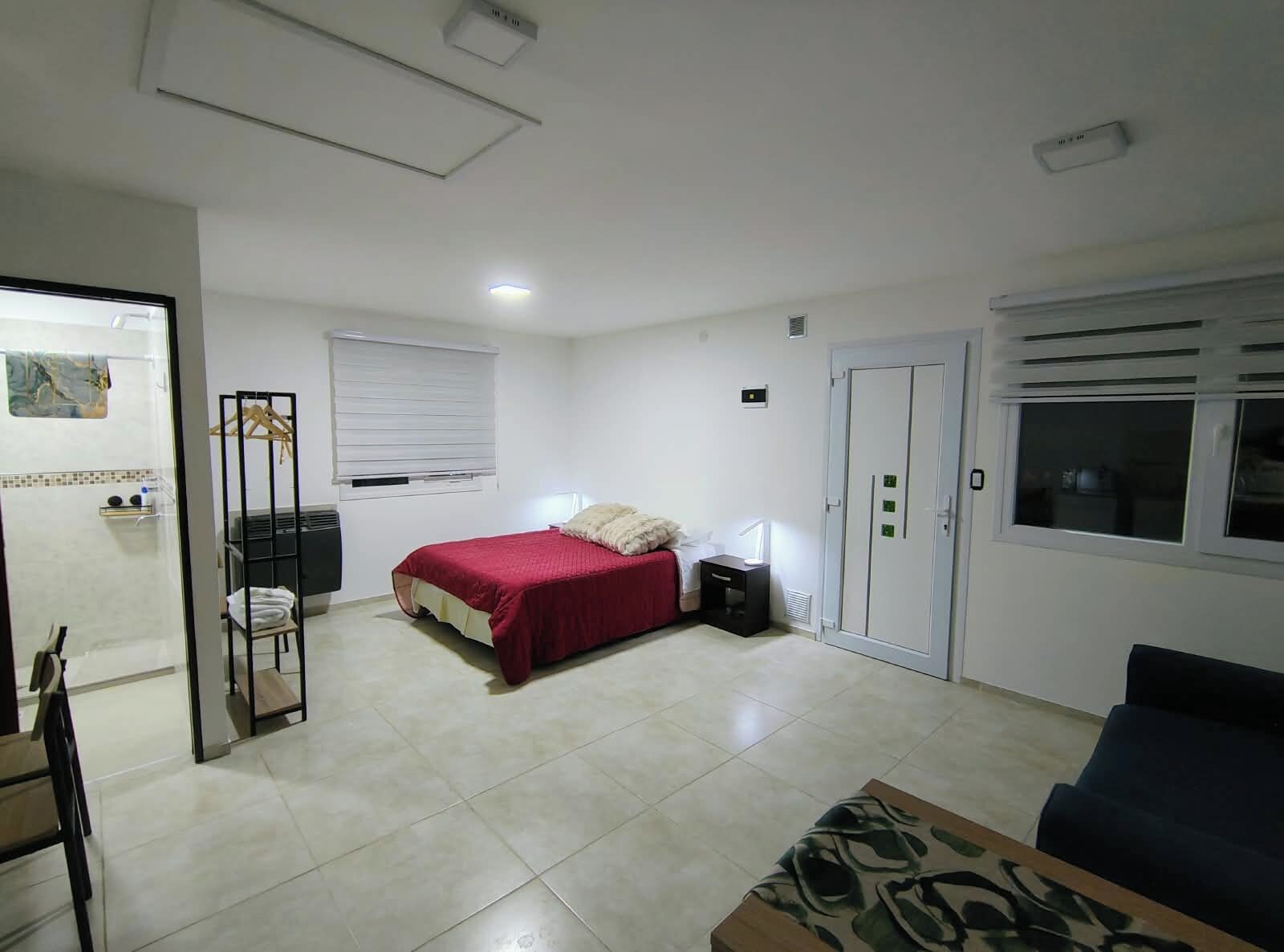 Ein Schlafzimmer mit Bett, Kleiderschrank, Nachttisch und Fenster.