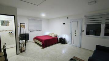 Ein Schlafzimmer mit Bett, Kleiderschrank, Nachttisch und Fenster.