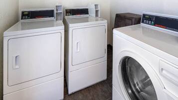 A laundry area with two front-loading washers and a dryer.