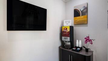 Ein Kaffeeangebot mit Folgers Kaffee, einer Kaffeemaschine und einem Schild mit den Kaffeestunden.