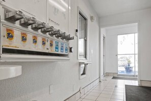 Ein Hotelzimmer mit einer Waschstation, ausgestattet mit Tide Waschmittel.