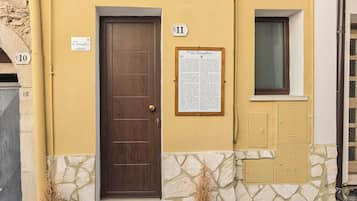 Un edificio con una porta marrone, il numero 11, e una targa con del testo.