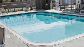 Una piscina rectangular con borde de azulejos, rodeada por una solera de hormigón.