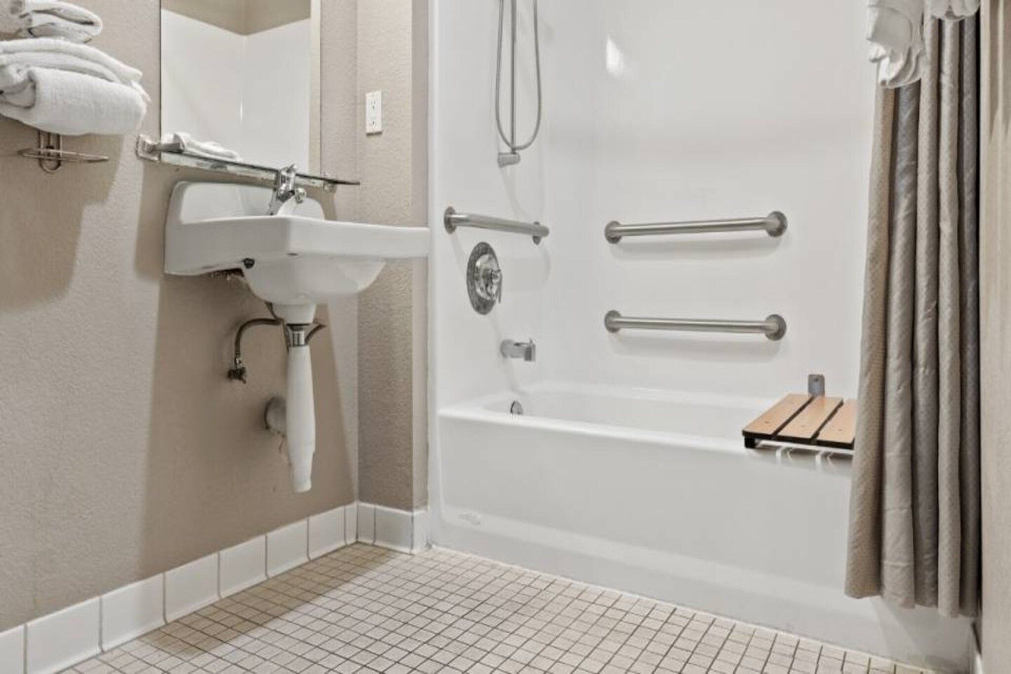 A bathroom with a white sink, a bathtub, and a shower.