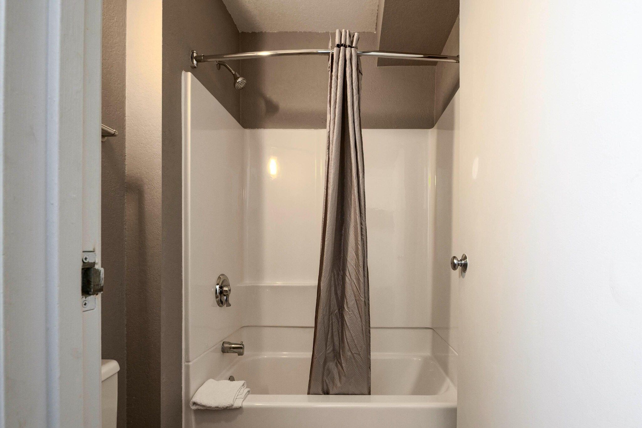 Ein Badezimmer mit Dusche, Toilette und Handtuchhalter.
