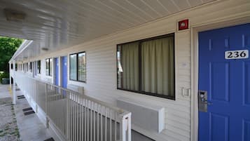 A row of motel rooms with individual doors, each marked with a number.