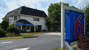 Een motel met een groot blauw bord waarop het nummer 6 staat.