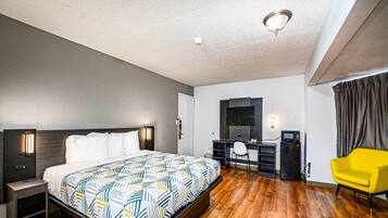 Une chambre d’hôtel moderne équipée d’un lit, d’un bureau, d’une chaise et d’un téléviseur.