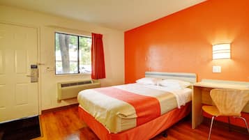 Een hotelkamer met een bed, een bureau en een stoel.