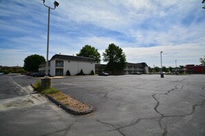 A parking lot with a building that has a balcony and a KFC restaurant in the background. - 2 Full Beds | Wethersfield (Wethersfield)
