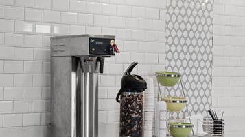 Eine Kaffeemaschine mit digitalem Display, eine Kaffeemühle und ein Kaffeeservice.