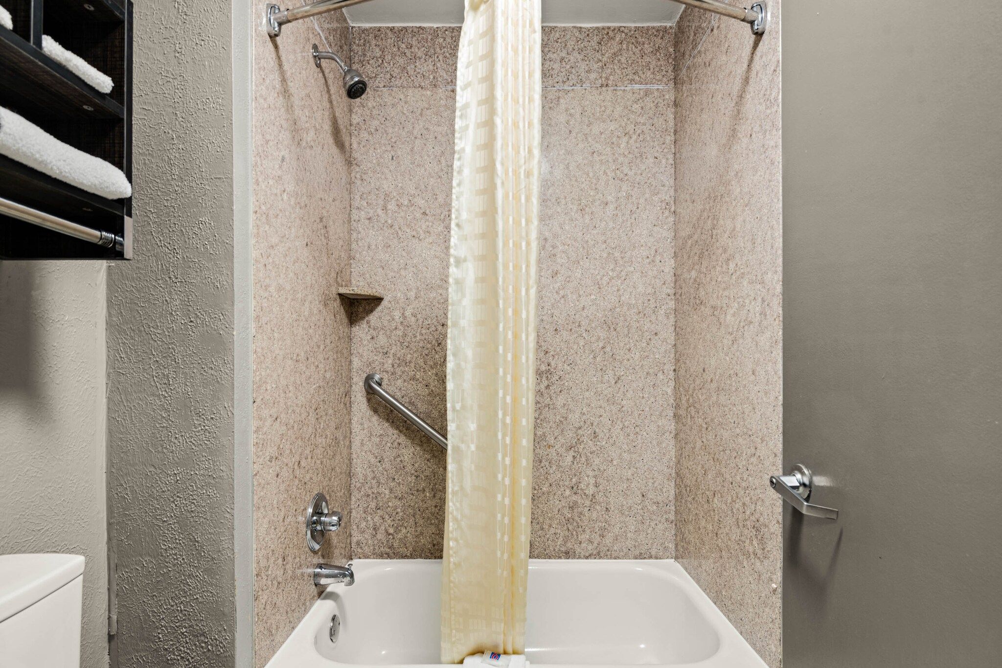 Une salle de bain avec une douche, une baignoire et des toilettes.
