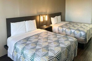Dos llits individuals amb llençols estampats a una habitació d'hotel.