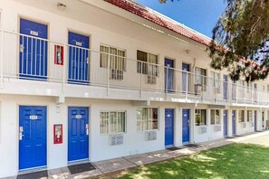 A multi-story motel with blue doors and white railings. - Motel 6 Tempe, Az - Scottsdale South_2 Q (Tempe)