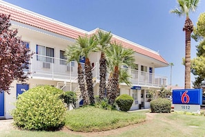 A motel with a red roof, multiple balconies, and palm trees. - 1 Queen Bed | Tempe, AZ (Tempe)