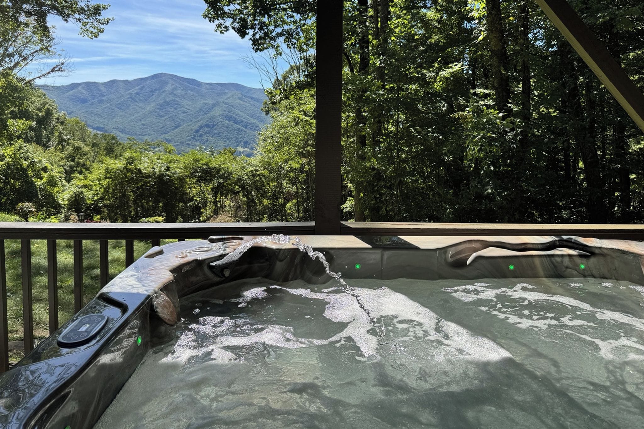 Un jacuzzi con vistas a montañas y árboles.