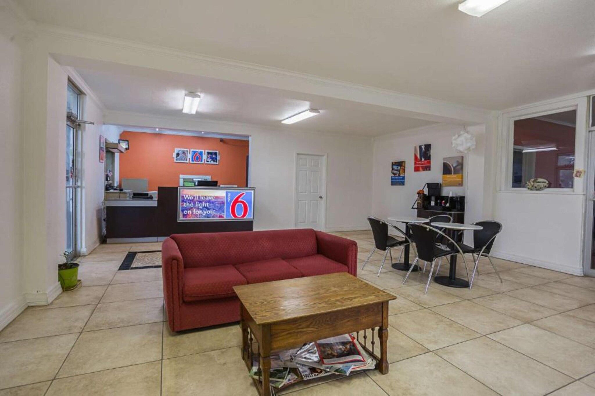 Ein Wohnzimmer mit einem roten Sofa, einem Holztisch und einem Fernseher im Hintergrund.