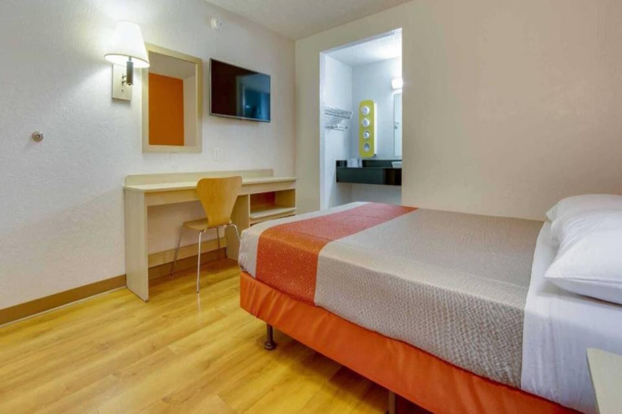 Ein Zimmer mit einem Bett, einem Schreibtisch und einem Stuhl.