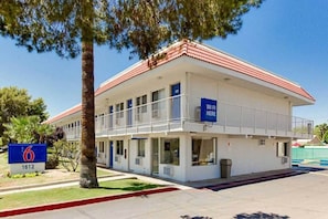 A two-story motel with a red-tiled roof, a sign indicating WiFi availability, and a number sign for room 6. - 2 Full Beds | ADA/RI Shower/Micfridge (Tempe)