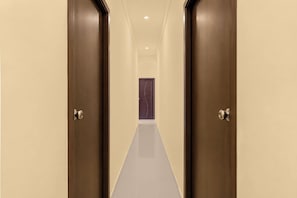 Un pasillo con dos puertas que conducen a una habitación con una puerta morada.