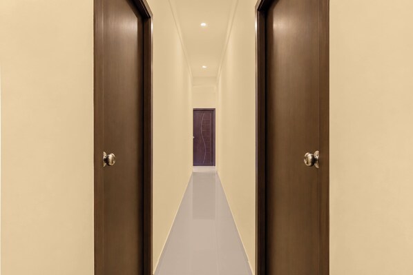 A hallway with two doors leading to a room with a purple door.