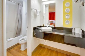 Une salle de bain équipée d’une douche, de toilettes, d’un lavabo et d’un miroir.