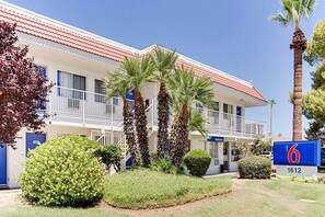 A motel with a red roof, multiple balconies, and palm trees. - 2 Full Beds | Tempe, AZ (Tempe)