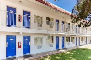 Un motel a più piani con porte blu e ringhiere bianche.