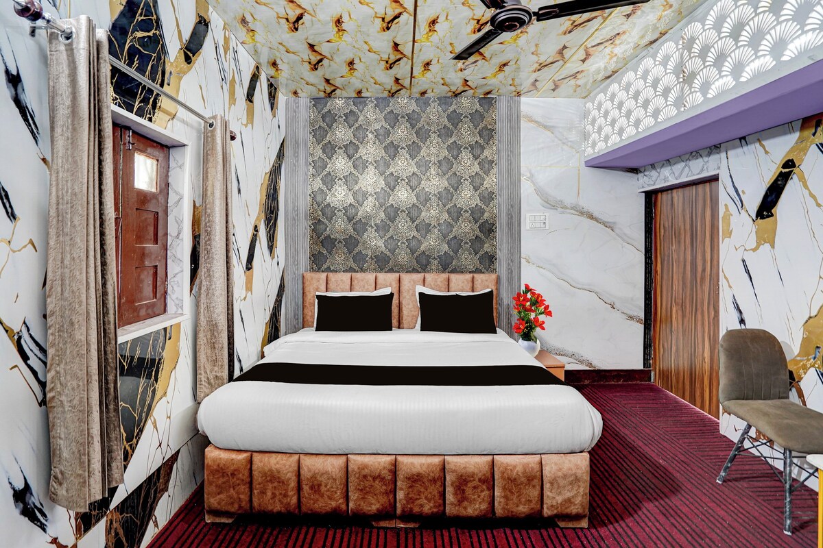A bedroom with a large bed, a wooden door, and a patterned wallpaper.