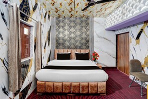 A bedroom with a large bed, a wooden door, and a patterned wallpaper. - Hotel O Sahaspur Dehradun (Pondha)