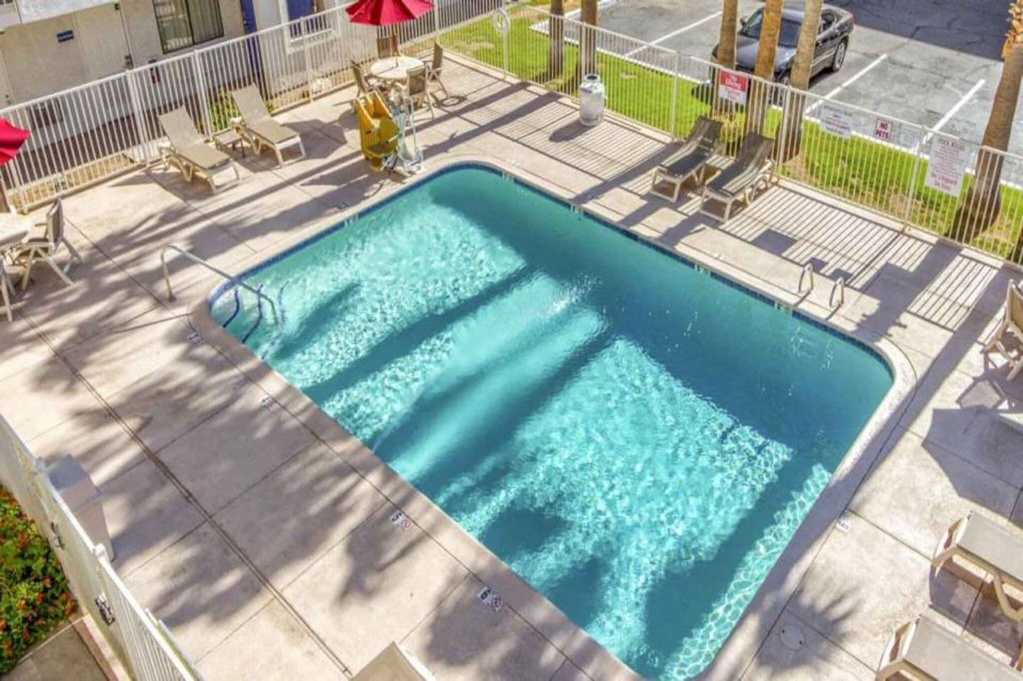 A rectangular swimming pool with a tiled deck surrounding it.