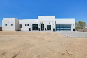 En moderne bygning med garage, store vinduer og en belagt indkørsel.