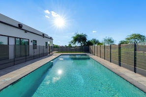 A rectangular swimming pool with clear blue water, surrounded by a paved deck and a fence. - 1 Mi to South Mtn Park! Home w/ Poolside Oasis (Phoenix)