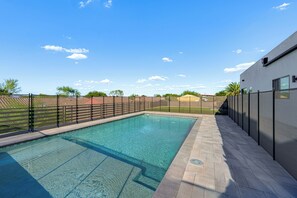 A rectangular swimming pool with clear blue water, surrounded by a tiled deck and a metal fence. - 1 Mi to South Mtn Park! Home w/ Poolside Oasis (Phoenix)