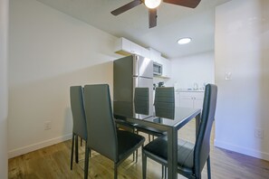 A dining area with a glass table and four chairs, a ceiling fan, and a kitchen in the background. - Centrally Located Lacey Escape: 2 Mi to Hospital (Lacey)