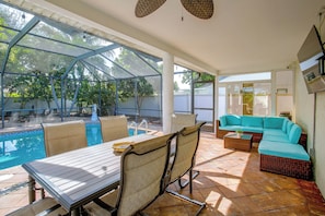 A covered outdoor area with a pool, seating, and a view of the surrounding greenery. - Family Oasis w/ Private Pool in Cape Coral! (Cape Coral)