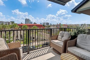 Ein Balkon mit Korbmöbeln und Blick auf die Stadt.