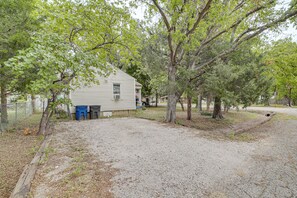 A single-story house with a gravel driveway, surrounded by trees. - Cozy, Convenient! Tulsa Stay Near Dtwn & Route 66 (Tulsa)