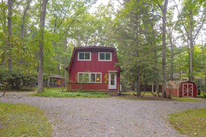 A two-story red house with a front porch, surrounded by trees and a gravel driveway. - Pet-Friendly w/ Dock & Fenced-In Yard in Swanton (Swanton)