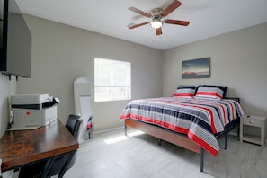 A bedroom with a bed, a desk with a printer, a ceiling fan, a window, and a painting on the wall. - Townhome 1 Mi to Midtown & Botanical Gardens! (Tucson)